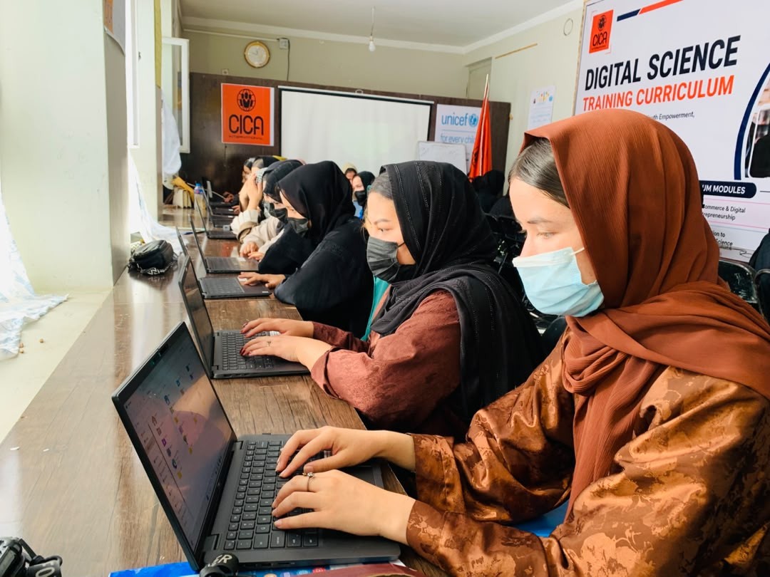 Women practising digital skills on laptops